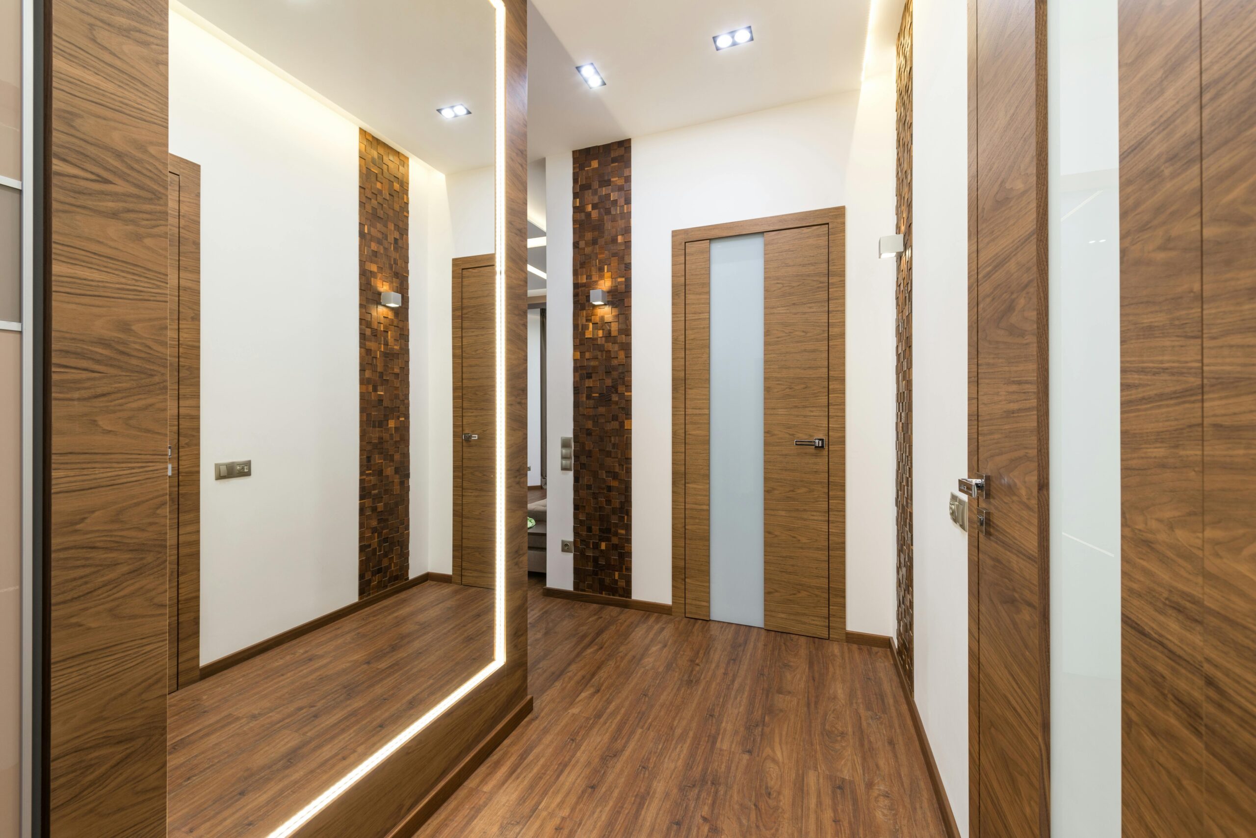 Sleek and contemporary hallway interior with wooden elements and warm lighting.